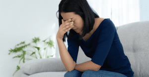 lady holding her head down after talking about living with a spouse with mental illness