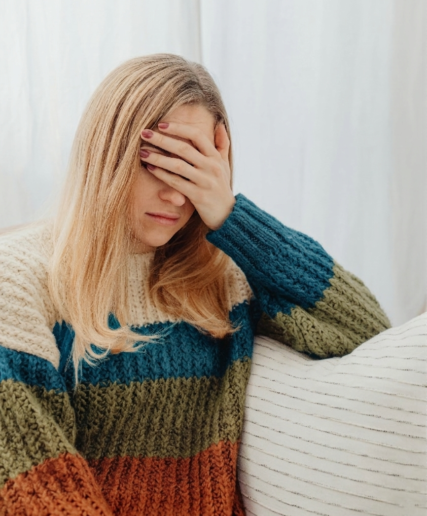 Lady covering face feeling anxiety symptoms